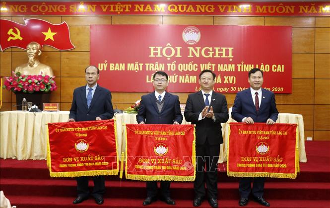Trong ảnh: Chủ tịch Ủy ban Mặt trận Tổ quốc Việt Nam tỉnh Lào cai Giàng Seo Vần trao cờ thi đua xuất sắc của Ủy ban Trung ương Mặt trận Tổ quốc Việt Nam cho các đơn vị. Ảnh: Quốc Khánh - TTXVN