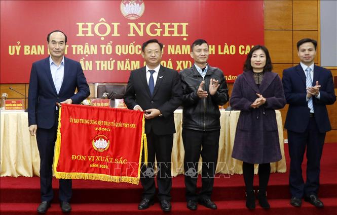 Trong ảnh: Đồng chí Vũ Xuân Cường, Phó Bí thư Thường trực Tỉnh ủy Lào Cai trao cờ thi đua xuất sắc của Ủy ban Trung ương Mặt trận Tổ quốc Việt Nam cho Mặt trận Tổ quốc Việt Nam tỉnh Lào Cai. Ảnh: Quốc Khánh - TTXVN