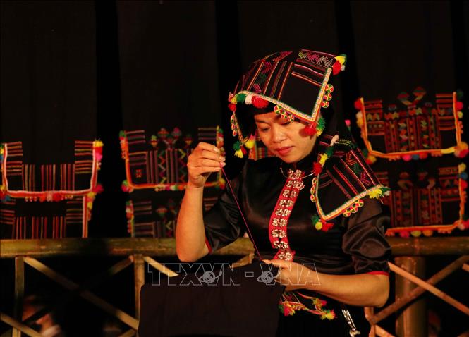 Trong ảnh: Các cô gái thái thể hiện sự khéo tay, duyên dáng trong kỹ thuật thêu vải nhằm thu hút các chàng trai đến tham gia Hạn Khuống. Ảnh: Nguyễn Oanh -TTXVN.