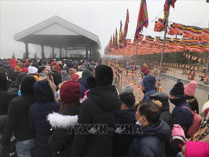 Trong ảnh: Hàng ngàn du khách phải xếp hàng dưới thời tiết 7 độ C để chờ lên cáp treo Fansipan. Ảnh Hồng Ninh - TTXVN