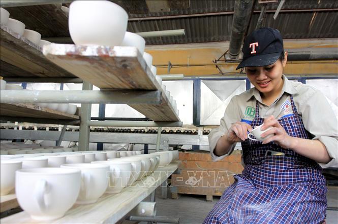 Trong ảnh: Công nhân vệ sinh các sản phẩm tại Công ty cổ phần gốm sứ Long Hầu. Ảnh: Thế Duyệt – TTXVN 
