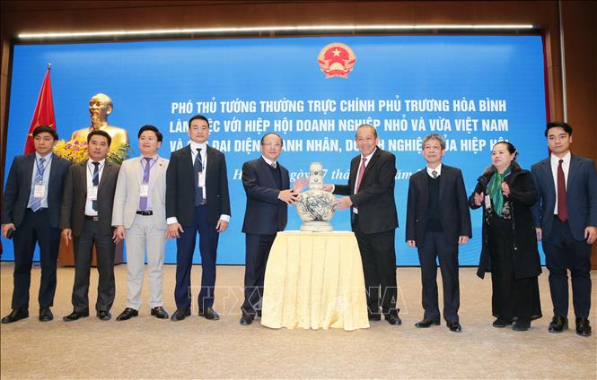 Trong ảnh: Phó Thủ tướng Thường trực Chính phủ Trương Hòa Bình tặng quà lưu niệm cho Hiệp hội Doanh nghiệp nhỏ và vừa Việt Nam. Ảnh: Doãn Tấn - TTXVN