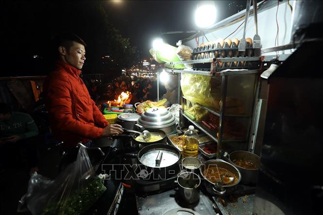 Trong ảnh: Gánh hàng rong phục vụ những món ăn nóng trên phố. Ảnh: Phan Tuấn Anh - TTXVN
