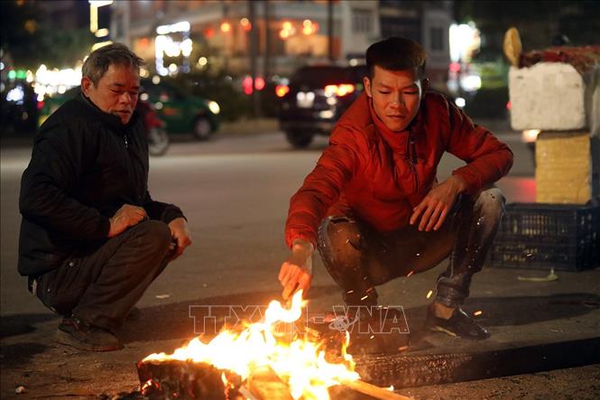Trong ảnh: Người dân đốt lửa lấy than để nướng ngô bán cho người đi đường. Ảnh: Phan Tuấn Anh - TTXVN
