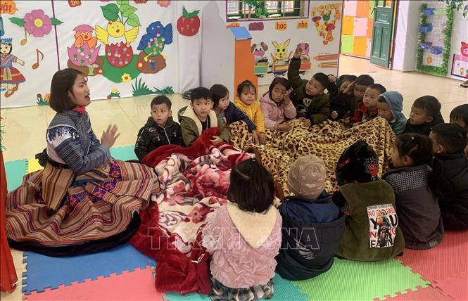 Photo: Teachers and children in a kindergarten in Simacai district, Lao Cai province have to use blankets to keep warm. VNA Photo