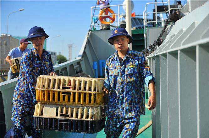 Photo: Soldiers of the High Command of Naval Zone 2 carry gifts and commodities to their ship to bring to soldiers and people doing duty at sea. VNA Photo: Minh Đức