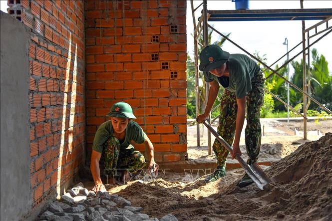 Trong ảnh: Bộ đội giúp dân xã Hòa Chánh làm nhà. Ảnh: Lê Sen – TTXVN