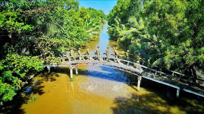 Trong ảnh: Bộ đội hành quân về xã Hòa Chánh để giúp dân. Ảnh: Lê Sen – TTXVN