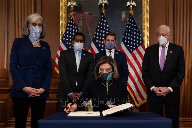 Trong ảnh: Chủ tịch Hạ viện Mỹ Nancy Pelosi (giữa, phía trước) ký điều khoản luận tội Tổng thống Donald Trump vừa được Hạ viện thông qua, tại Washington, DC., ngày 13/1/2021. Ảnh: AFP/TTXVN