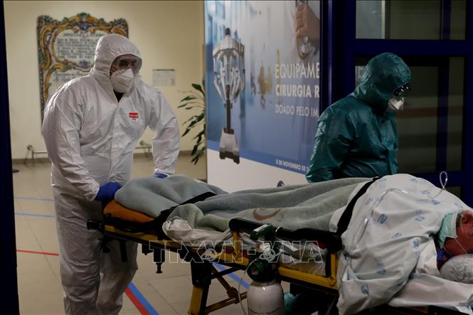 Trong ảnh: Nhân viên y tế chuyển bệnh nhân nhiễm COVID-19 tới bệnh viện ở Lisbon, Bồ Đào Nha. Ảnh: THX/TTXVN