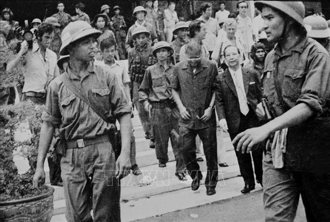 Trong ảnh: Đại úy Phạm Xuân Thệ (bên phải), Trung đoàn phó Trung đoàn 66, Sư đoàn 304 (Quân đoàn 2) cùng các chiến sĩ Quân giải phóng dẫn giải Tổng thống Dương Văn Minh và Thủ tướng Vũ Văn Mẫu của Ngụy quyền Sài Gòn tới Đài Phát thanh để đọc lời tuyên bố đầu hàng vô điều kiện, trưa 30/4/1975. Ảnh: TTXVN