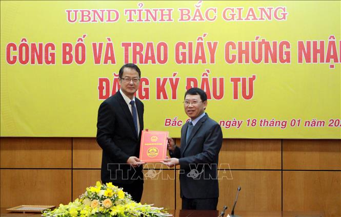 Trong ảnh: Chủ tịch UBND tỉnh Bắc Giang Lê Ánh Dương (phải) trao Giấy chứng nhận đăng ký đầu tư cho Dự án “Nhà máy Fukang Technology” của nhà đầu tư Foxconn Singapore PTE Ltd. Ảnh: Đồng Thúy-TTXVN