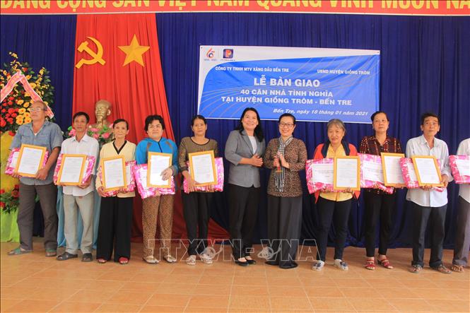 Trong ảnh: Phó Chủ tịch UBND tỉnh Nguyễn Thị Bé Mười trao quyết định nhận nhà cho các hộ dân. Ảnh Công Trí-TTXVN