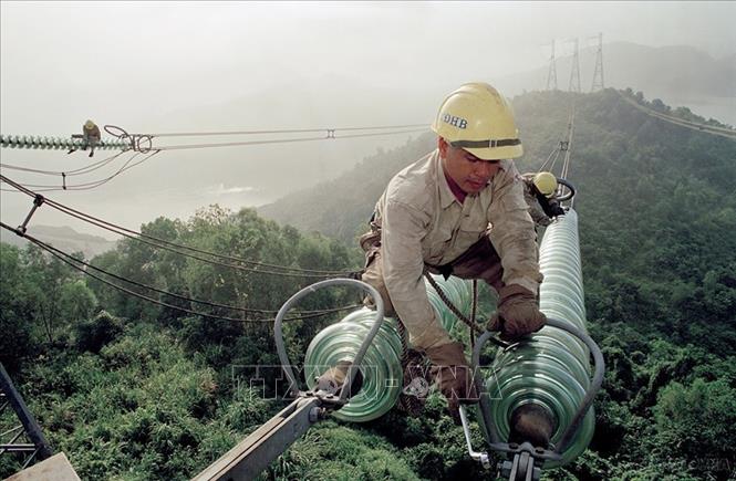 Đường dây truyền tải điện siêu cao áp 500kV Bắc - Nam được khởi công tháng 4/1992 và hoàn thành đóng điện ngày 27/5/1994, đóng vai trò quyết định nhiệm vụ điện khí hóa đất nước, chấm dứt tình trạng thiếu điện liên miên ở miền Trung và miền Nam suốt nhiều năm, điều hòa lưới điện của cả nước, góp phần quan trọng thúc đẩy sự nghiệp công nghiệp hóa, hiện đại hóa. Trong ảnh: Công nhân Công ty truyền tải điện Hòa Bình bảo dưỡng đường dây 500KV tại vị trí số 1. Ảnh: Ngọc Hà - TTXVN