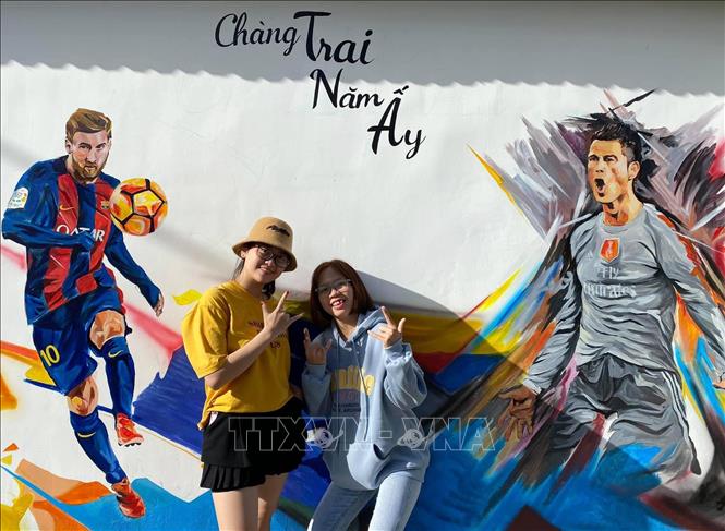 Trong ảnh: Du khách chụp ảnh lưu niệm với các bức bích họa. Ảnh: TTXVN phát