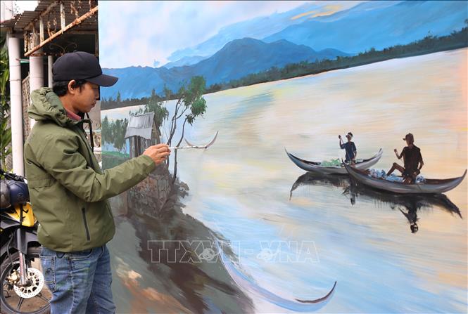 Trong ảnh: Họa sĩ vẽ bức tranh với khung cảnh thanh bình của làng Hòn Thiên. Ảnh: Nguyễn Thành – TTXVN