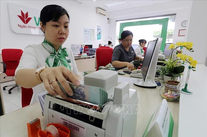 Cơ cấu tín dụng chuyển dịch tích cực, tập trung vốn vào các lĩnh vực sản xuất kinh doanh, nhất là các lĩnh vực ưu tiên theo chủ trương của Chính phủ. Trong ảnh: Chính sách tiền tệ chủ động, linh hoạt, thị trường ngoại hối và tỉ giá đi vào ổn định, lãi suất giảm dần. Ảnh: Trần Việt - TTXVN
