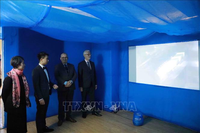 Trong ảnh:  Ngài Guido Hildner Đại sứ Cộng hòa Liên bang Đức tại Việt Nam (ngoài cùng bên phải),  Ngài Paul Jansen Đại sứ Vương  quốc Bỉ tại Việt Nam (thứ 2 từ bên phải sang) và Tác giả đạo diễn Nguyễn Lê Hoàng Việt (thứ 2 từ bên trái sang) thưởng thức tác phẩm tại buổi triển lãm. Ảnh: Vũ Sinh - TTXVN