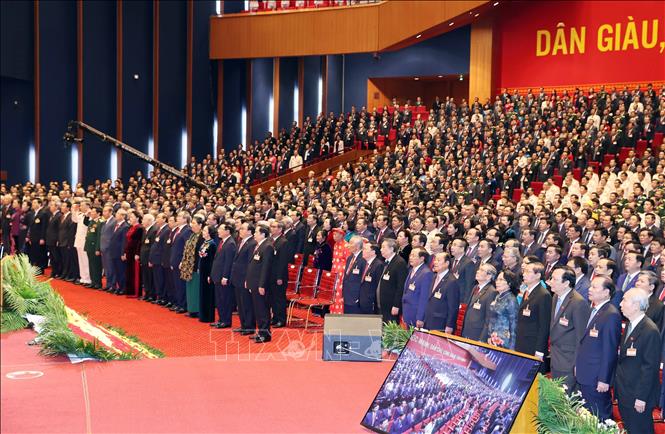 Photo: Delegates salute the national flags at the 13th National Party Congress's opening session. VNA Photo