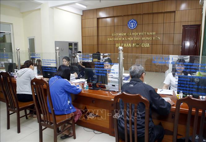 Trong ảnh: Nhân viên bảo hiểm y tế Hưng Yên hướng dẫn người dân tham gia bảo hiểm xã hội. Ảnh: Phạm Kiên - TTXVN