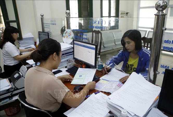Trong ảnh: Nhân viên bảo hiểm y tế Hưng Yên hướng dẫn người dân tham gia bảo hiểm xã hội. Ảnh: Phạm Kiên - TTXVN
