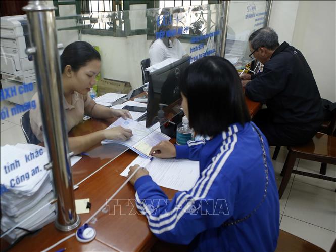 Trong ảnh: Nhân viên bảo hiểm y tế Hưng Yên hướng dẫn người dân tham gia bảo hiểm xã hội. Ảnh: Phạm Kiên - TTXVN