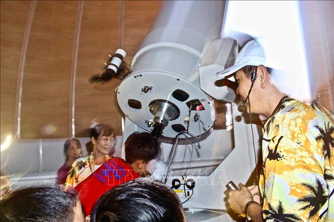 Trong ảnh: Các bạn nhỏ được trực tiếp ngắm mặt trăng thông qua kính thiên văn của Đài thiên văn Nha Trang. Ảnh: Phan Sáu - TTXVN