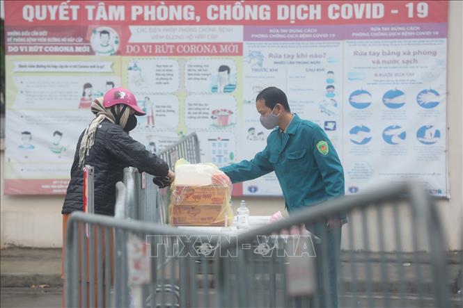 Trong ảnh: Người nhà gửi đồ tiếp tế cho người bên trong khu cách ly. Ảnh: Minh Quyết - TTXVN