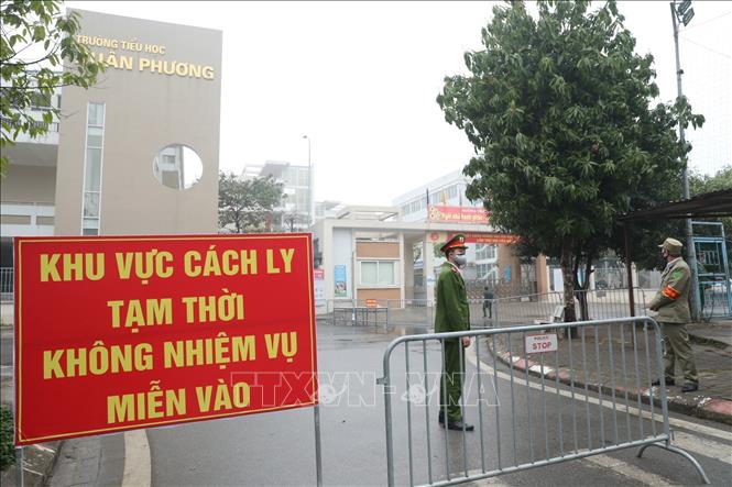 Trong ảnh: Lực lượng chức năng lập chốt tại cổng trường tiểu học Xuân Phương. Ảnh: Minh Quyết - TTXVN