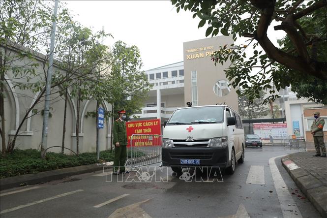 Trong ảnh: Lực lượng chức năng lập chốt tại cổng trường tiểu học Xuân Phương. Ảnh: Minh Quyết - TTXVN