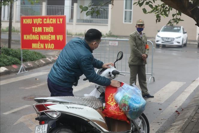 Trong ảnh: Người nhà gửi đồ tiếp tế cho người bên trong khu cách ly. Ảnh: Minh Quyết - TTXVN