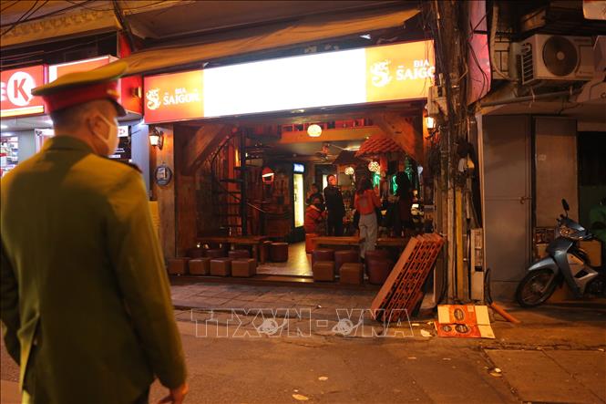 Trong ảnh: Công an nhắc quán Xupito bar đóng cửa đúng giờ ( ảnh chụp lúc 23h47 ngày 31/1/2021). Ảnh: Hoàng Hiếu - TTXVN