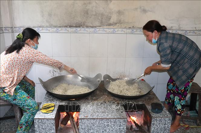 Trong ảnh: Sản xuất mứt dừa thủ công. Ảnh: Huỳnh Phúc Hậu - TTXVN