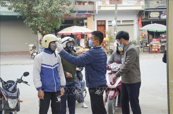 Trong ảnh: Đo thân nhiệt cho học sinh khi vào khu vực trường học. Ảnh: Xuân Tư – TTXVN