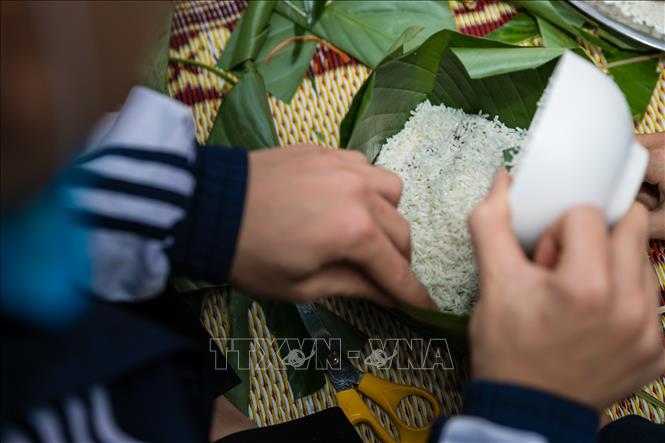 Trong ảnh: Học sinh trường THPT Nguyễn Trường Tộ tự tay tải nghiệm hoạt động gói bánh chưng và những phần quà nhỏ xinh để tặng những bạn học có hoàn cảnh khó khăn. Ảnh: Bích Huệ - TTXVN