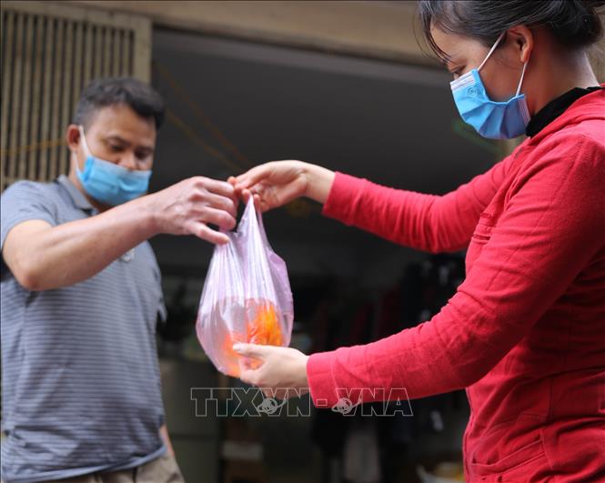 Trong ảnh: Người dân mua cá chép chuẩn bị làm lễ cúng ông Công, ông Táo. Ảnh: Hoàng Hiếu - TTXVN
