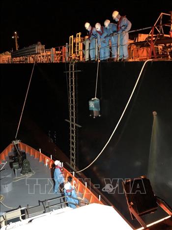 Trong ảnh: Các nhân viên cứu nạn của Việt Nam đưa hành lý của thuyền viên nước ngoài bị bệnh sang tàu cứu nạn Việt Nam. Ảnh: TTXVN phát