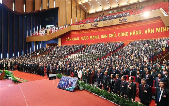 Các đại biểu thực hiện nghi thức chào cờ, chính thức bế mạc Đại hội XIII của Đảng. Ảnh: TTXVN
