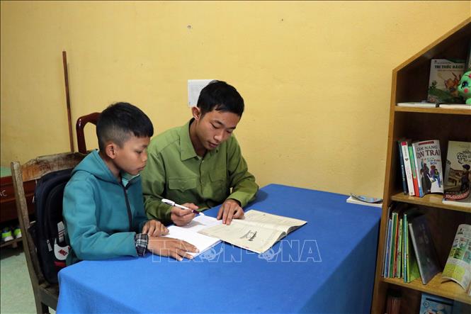 Trong ảnh: Trung úy Phạm Thái Sơn, Đồn Biên phòng Cửa khẩu A Đớt, ướng dẫn em Lê Văn Thìn sinh học tập. Ảnh: Đỗ Trưởng – TTXVN