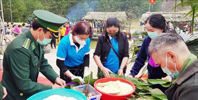 Cán bộ chiến sỹ biên phòng, hội viên phụ nữ và bà con nhân dân vùng biên giới Hóa Sơn, huyện Minh Hóa, Quảng Bình phấn khởi tham gia gói bánh chưng. Ảnh: Võ Dung - TTXVN