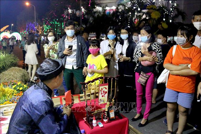 Người dân và du khách đeo khẩu trang khi tham quan và tham gia các hoạt động vui chơi tại đường hoa Phan Thiết để phòng ngừa dịch COVID -19. Ảnh: Nguyễn Thanh - TTXVN