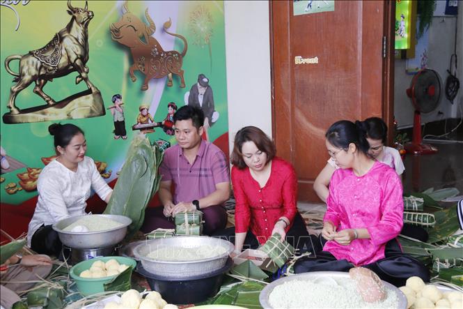 Trong ảnh: Mọi người cùng nhau trải qua những khoảnh khắc đầm ấm trong những ngày giáp Tết Nguyên đán. Ảnh: Phạm Kiên - Phóng viên TTXVN tại Lào