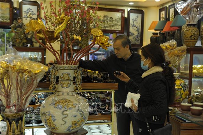 Trong ảnh: Chủ cửa hàng gốm Thư tư vấn cho khách. Ảnh: Mạnh Khánh-TTXVN