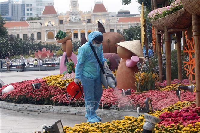 Trong ảnh: Nhân viên y tế dự phòng phun khử khuẩn tại khu vực Đường Hoa xuân năm 2021, chiều 30 Tết. Ảnh: Thanh Vũ - TTXVN