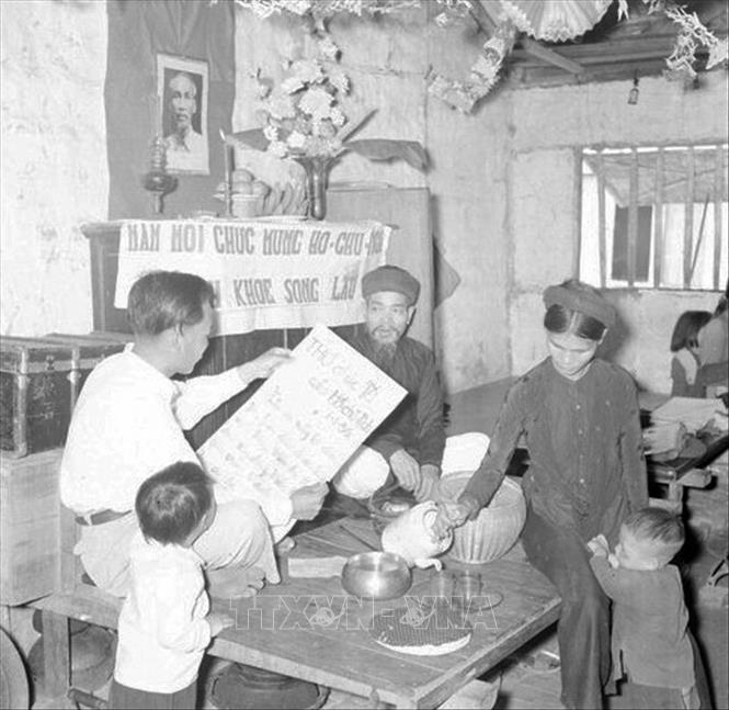 Trong ảnh: Sáng mùng một Tết, cả gia đình ngồi trước bàn thờ Tổ quốc nghe đọc thư chúc Tết của Chủ tịch Hồ Chí Minh. Ảnh: TTXVN