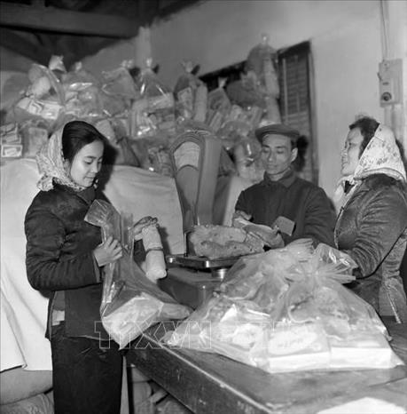 Trong ảnh: Công ty Bách hóa Bán lẻ Hà Nội tổ chức đóng gói hàng Tết đúng tiêu chuẩn định lượng và điều vận tốt hàng hóa đến bán tại các cửa hàng bách hóa và các quầy hàng tập thể ở cơ quan, xí nghiệp, phục vụ nhân dân trong dịp Tết Canh Tuất 1970. Ảnh: Trần Phác - TTXVN