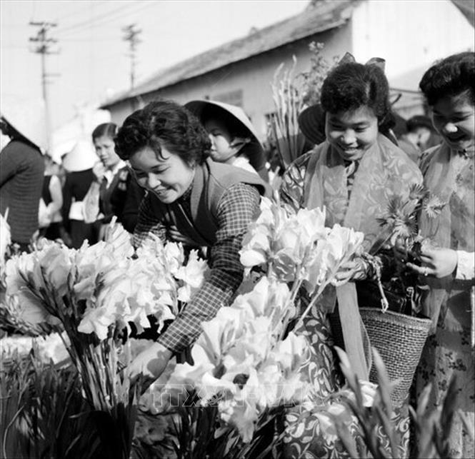 Trong ảnh: Thiếu nữ Hà Nội đi chợ hoa trong những ngày giáp Tết Nguyên đán. Ảnh: TTXVN