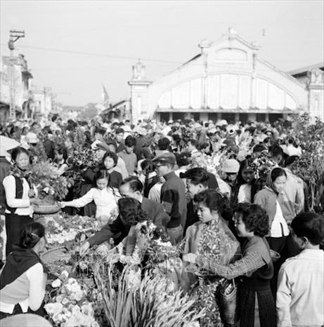 Trong ảnh: Người dân tấp nập đi mua hoa Tết. Ảnh: TTXVN