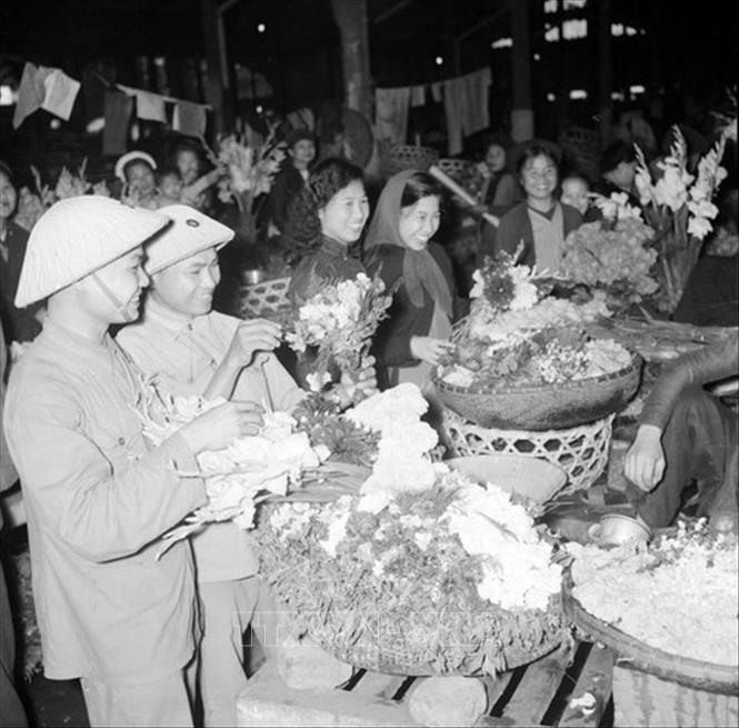 Trong ảnh: Bộ đội và nhân dân đi mua sắm hàng Tết. Ảnh: TTXVN