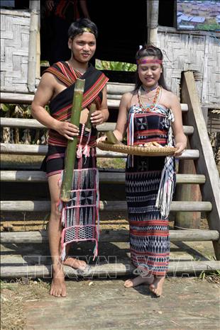 Trong ảnh: Cô dâu chú rể mang rượu thịt đi mời mọi người tới dự. Ảnh: TTXVN